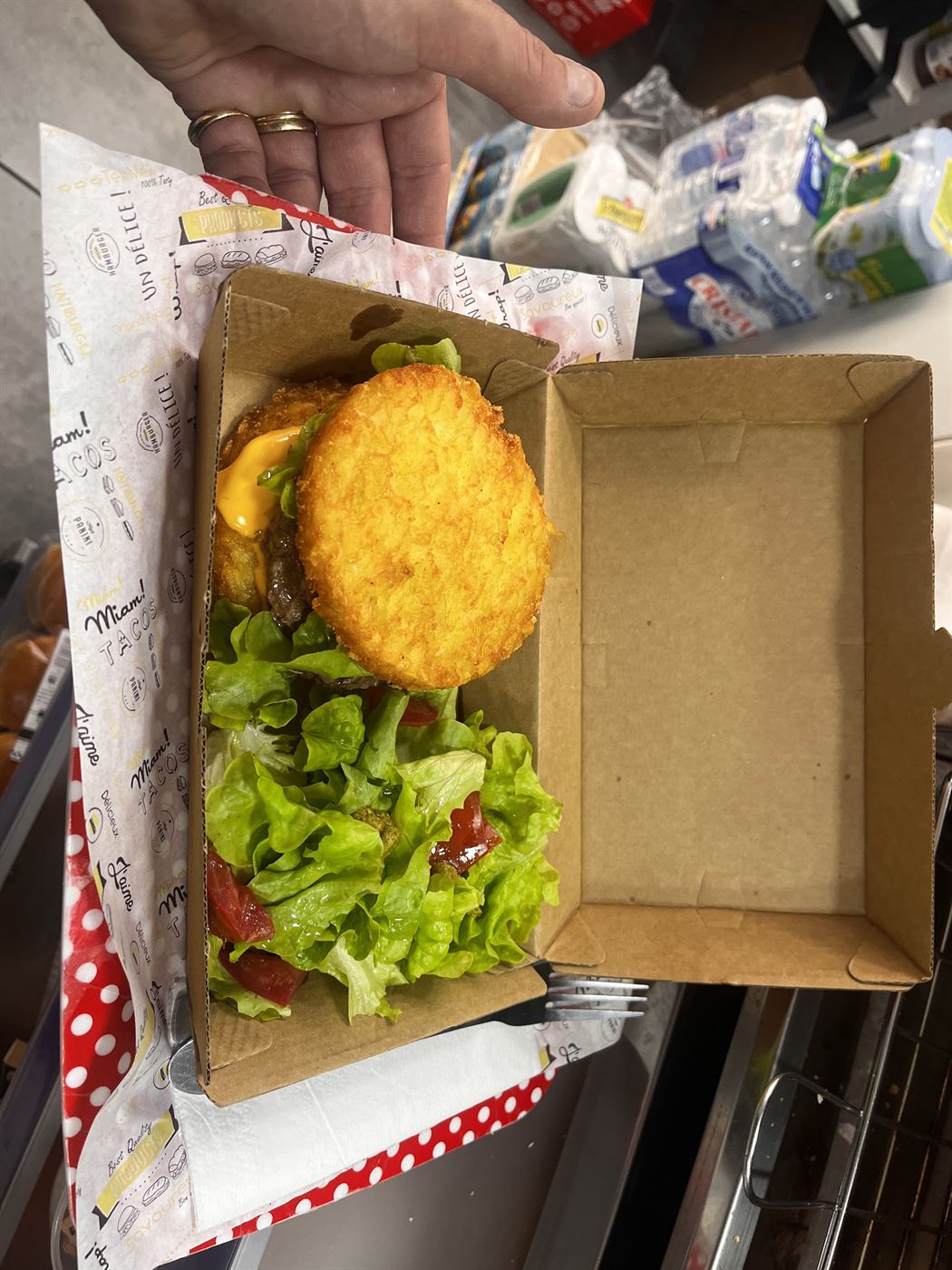 Burger garni de salade et de steak dans sa boîte en carton