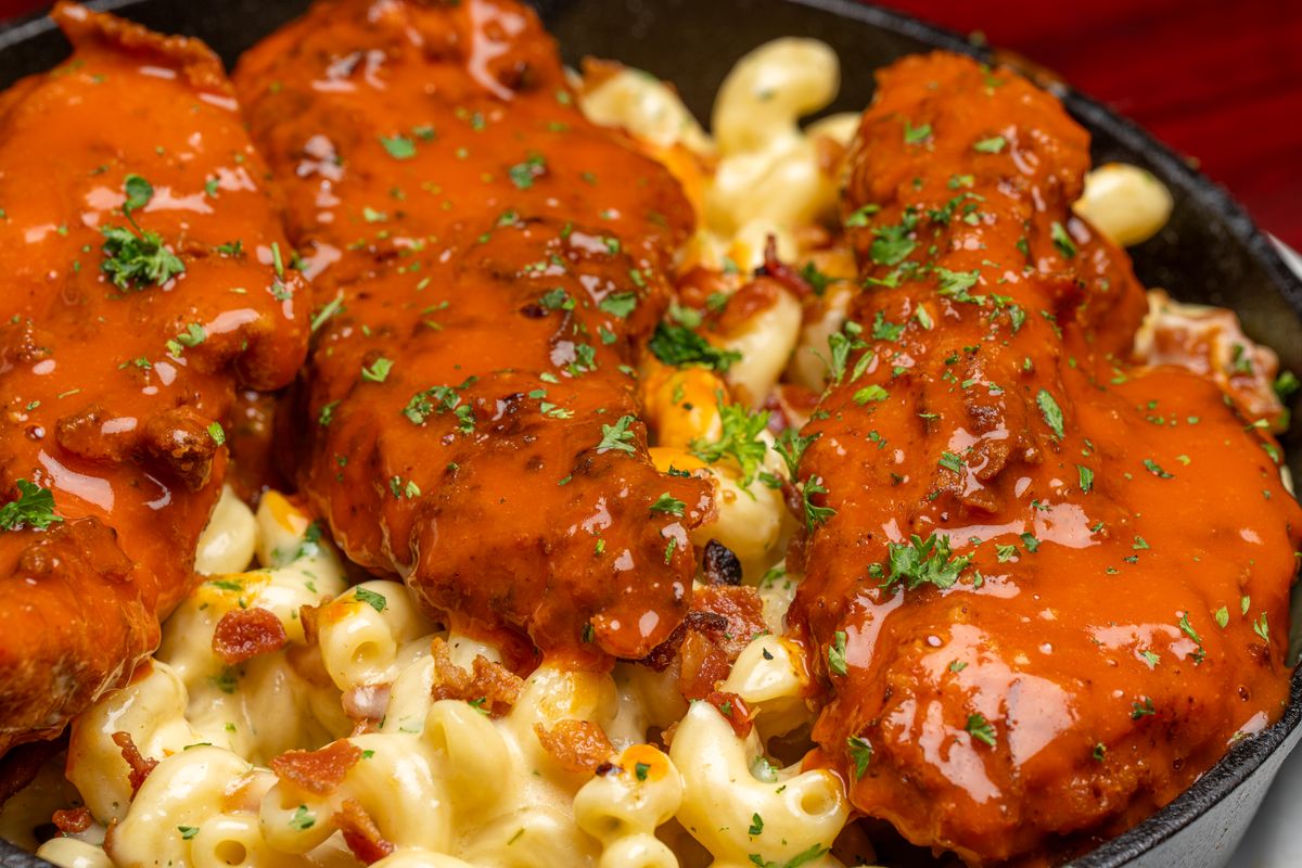 Pâtes gratinées surmontées de tenders croustillants nappés de sauce