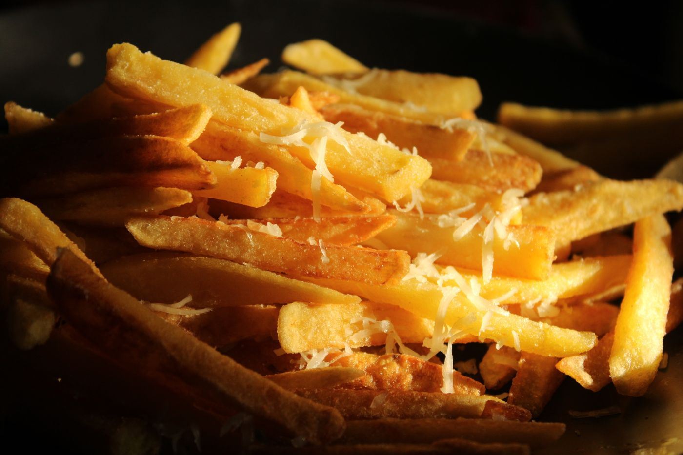 Frites dorées recouvertes de fromage râpé