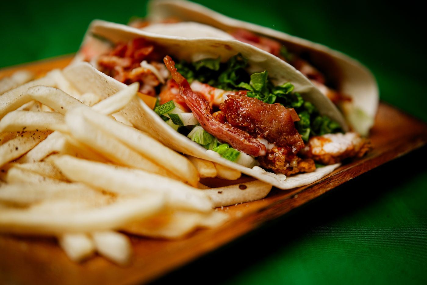 Tacos garnis de poulet croustillant et de frites sur une planche en bois
