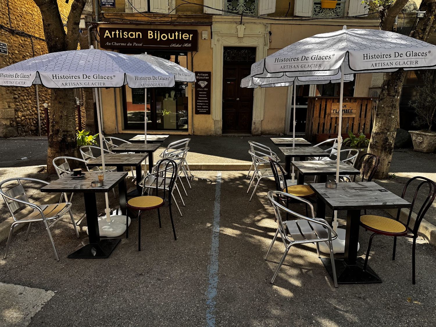 Terrasse ombragée de La Fringale avec tables et parasols